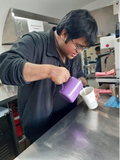 Participant Rocky frothing milk in coffee cart for coffee order.