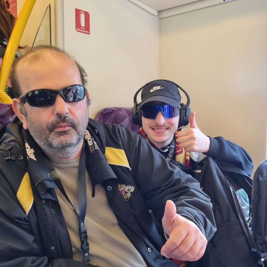 Two people on a Vline train as a part of a Recreation program out in the community.