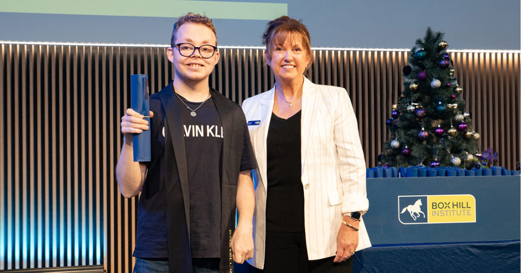 Alkira participant Joshua holding up his certificate when graduating from the Momentum program.