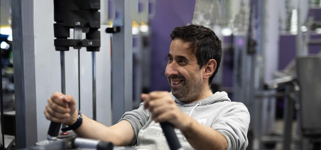 Alkira participant Frank uses a strength training machine at the gym as part of his Alkira day programs.