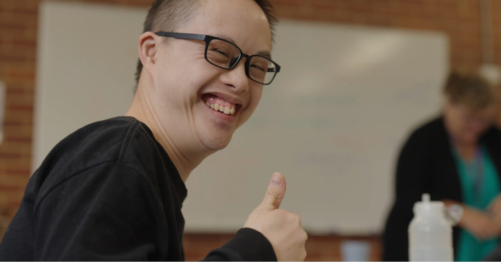 Matthew posing with a thumbs up in the Networks classroom.