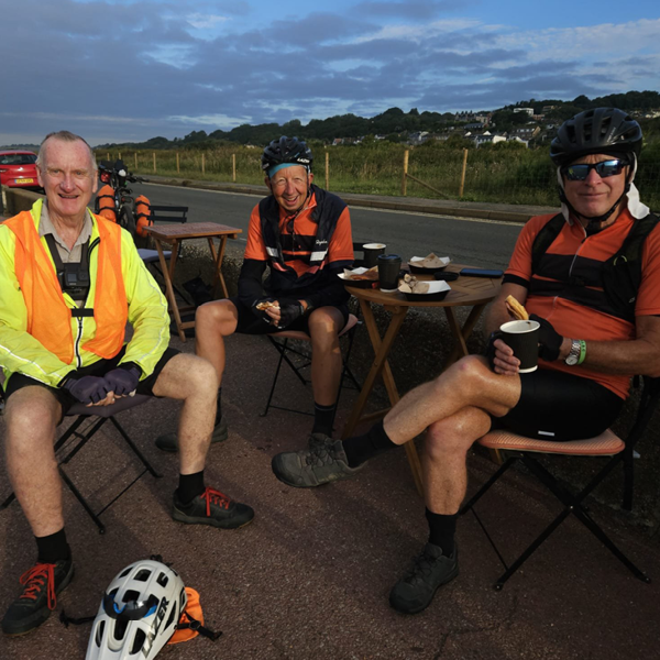Peter Harrison, Chris Jones and Steve Seymour taking a coffee break with a dark dusk sky in the background.